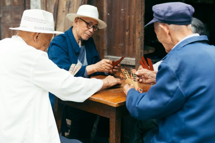Photo by Joey Huang a group of elderly people playing a game of cards