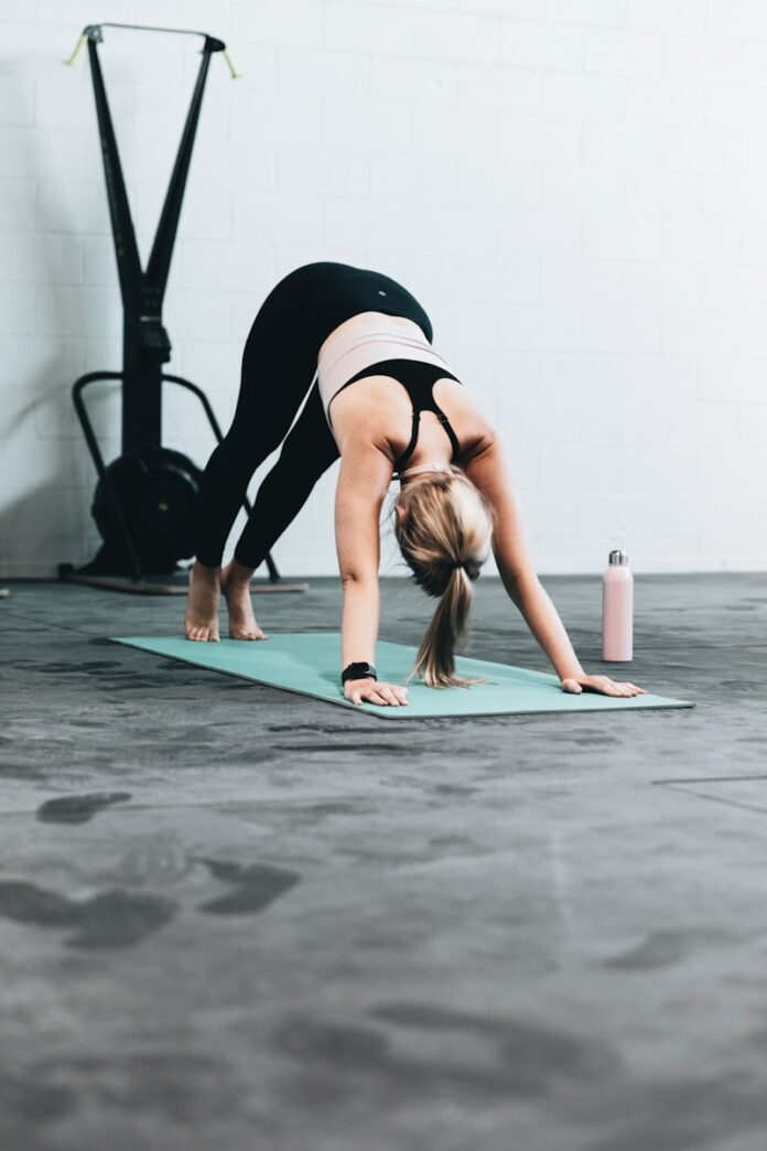 Photo by LOGAN WEAVER | @LGNWVR woman in black sports bra and blue denim jeans doing yoga