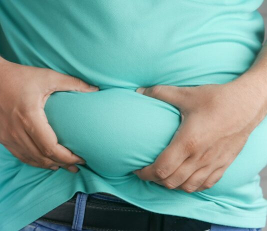 전문가들이 추천하는 뱃살 타파에 도움되는 5가지 운동 루틴 a man holding his stomach with his hands