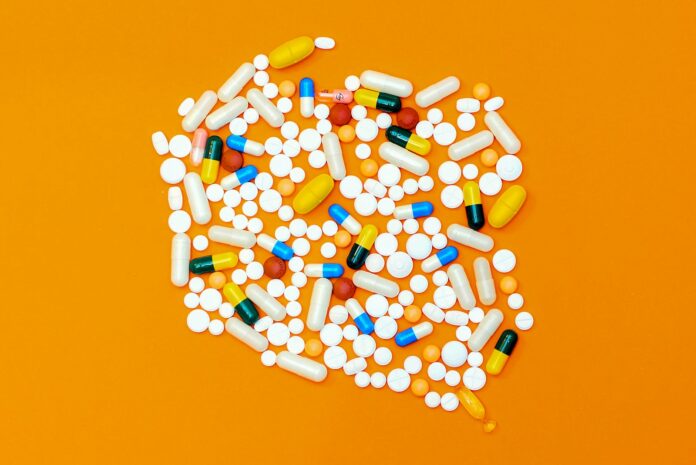 Photo by Michał Parzuchowski white and orange medication pill