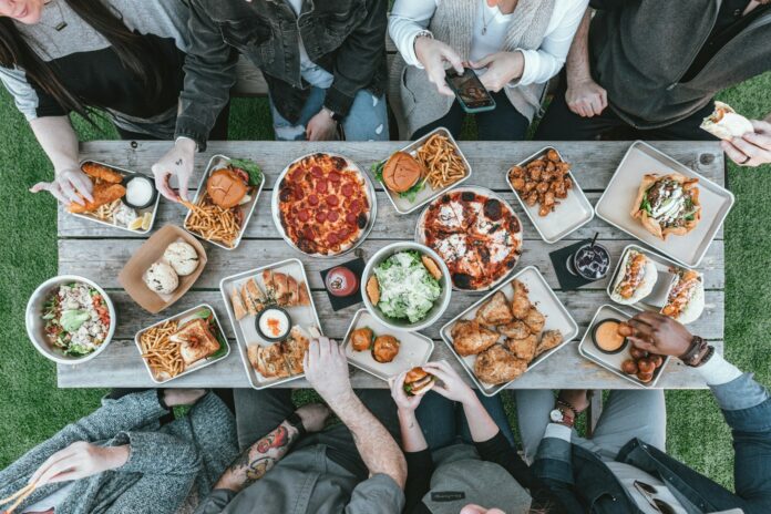 Photo by Spencer Davis a group of people sitting around a table with food