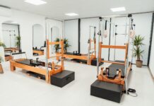 필라테스, 몸과 마음의 균형을 찾는 현대인의 건강 비법 a gym with a row of machines and mirrors