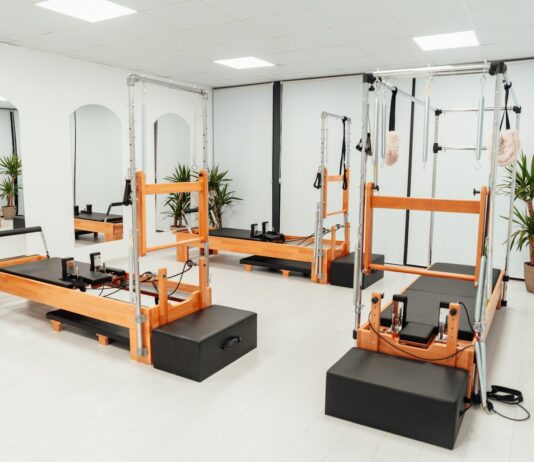 필라테스, 몸과 마음의 균형을 찾는 현대인의 건강 비법 a gym with a row of machines and mirrors