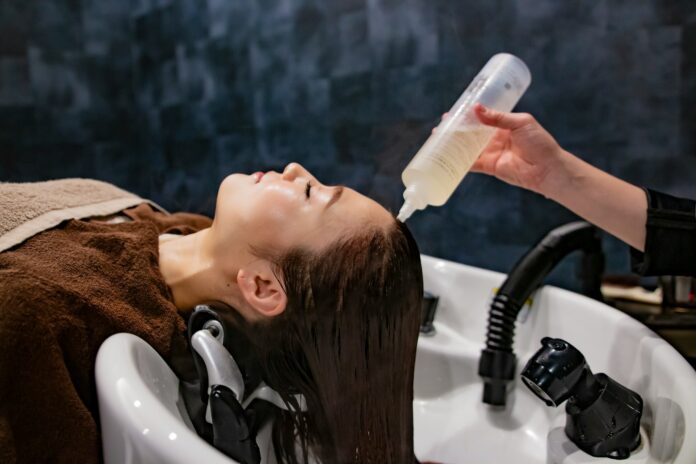 Photo by QUENTIN Mahe a woman getting her hair washed with a hair dryer
