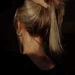 두피를 위한 ‘슬로우 뷰티’ 열풍…건강한 헤어 관리의 일상화 a woman with her hair in a bun