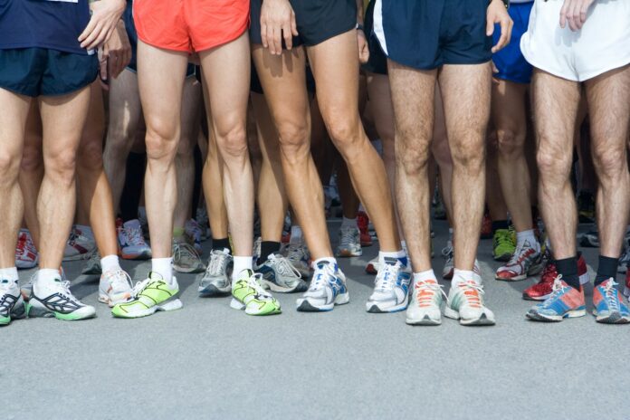Photo by Rob Wilson man in blue shorts and white nike sneakers
